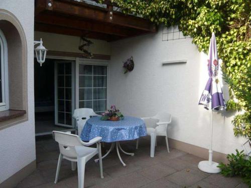 乌姆基希Villa Roder的庭院里配有桌椅和遮阳伞