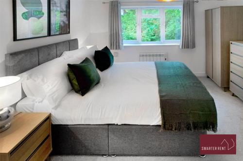 BlackwaterFarnborough - Lovely 1 Bedroom House的卧室配有带绿色枕头的大型白色床