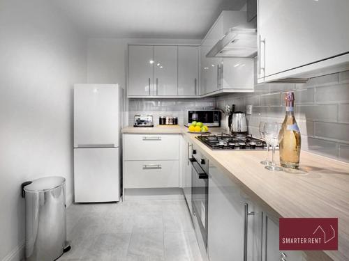 沃金厄姆Wokingham - 2 Bed Modern House - Parking的厨房配有白色橱柜和白色冰箱。