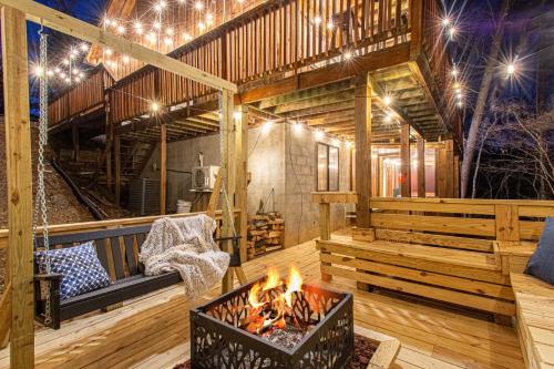 鸽子谷The Family Stone Luxe Cabin Sleeps 12 Hot tub Dogfriendly Dollywood的带壁炉的客房位于带灯的甲板上