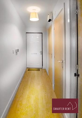 希钦Hitchin - Sharps Court的一条空的走廊,有白色的门和硬木地板