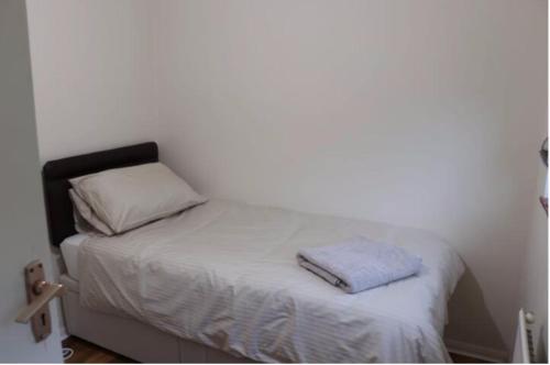 KenleyWellesley, Central London Living in peaceful Suburb的白色客房内的小床,配有枕头