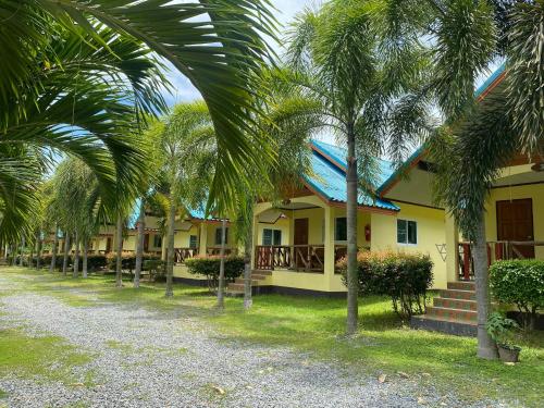 象岛Baanrimklong bungalow的一排棕榈树在房子前面