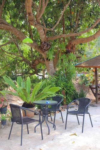 象岛Baanrimklong bungalow的树前的桌椅