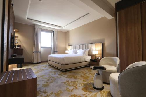 泰布克فندق لارتشي تبوك Larichy Tabuk的配有一张床和一把椅子的酒店客房