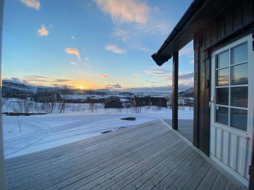 KvalsundHytte i Neverfjord.的雪中房屋甲板的景色