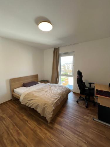 杜塞尔多夫Wohnung Nähe Flughafen und Messe的一间卧室配有一张床、一张书桌和一个窗户。