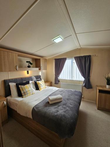 塞顿港Beautiful caravan near Edinburgh nr 14的一间卧室配有一张大床和紫色窗帘