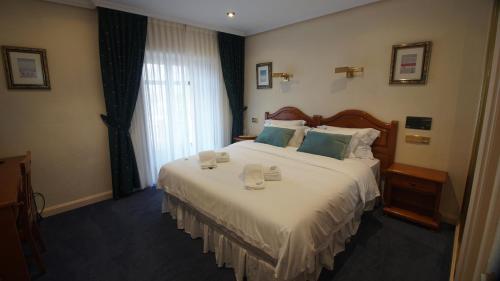 里亚萨HOTEL RIAZA的酒店客房,配有一张大床,上面有2杯