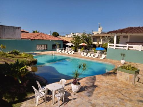 瓜拉派瑞格拉帕萨达酒店的一个带白色椅子和桌椅的游泳池