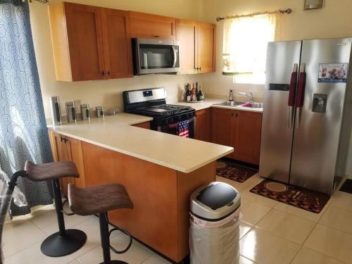 波特莫尔Gated Cozy Urban Luxe Retreat的厨房配有不锈钢冰箱和台面