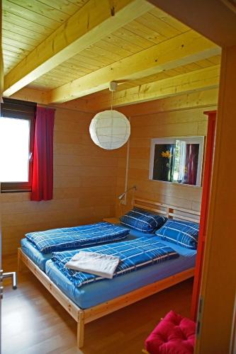 MundelfingenFeriendorf Wutachschlucht的木制客房内的一间卧室,配有一张床
