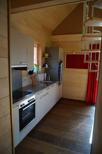 MundelfingenFeriendorf Wutachschlucht的厨房配有白色橱柜和炉灶烤箱。