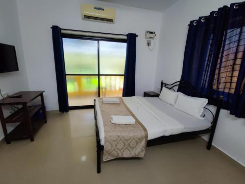 卡兰古特Maria Comfort Stay的一间卧室设有一张床和一个大窗户