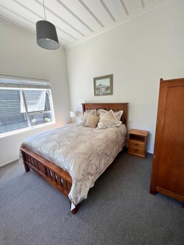 奥克兰Eden Park House Auckland的一间卧室设有一张大床和一个窗户。