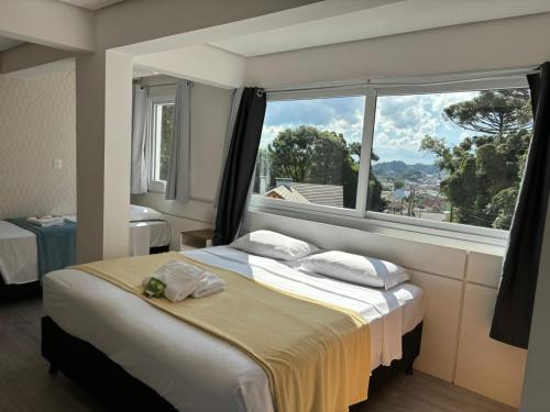 卡内拉Hotel Golden Hills的一间卧室设有一张床和一个大窗户