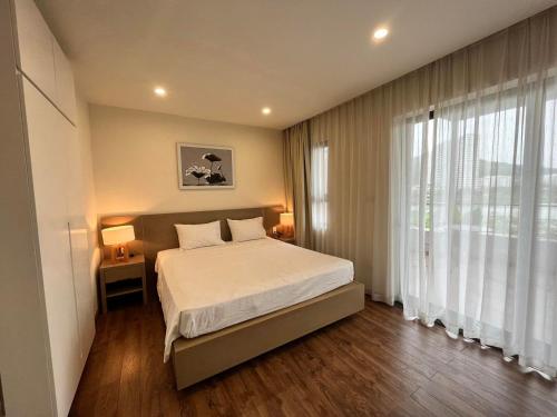 下龙湾Royal Lotus Hạ Long Resort - kiko resort的一间卧室设有一张床和一个大窗户