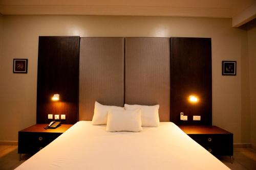 哈科特港Genesis Reventon Hotel的卧室配有一张带白色床单和枕头的大床。