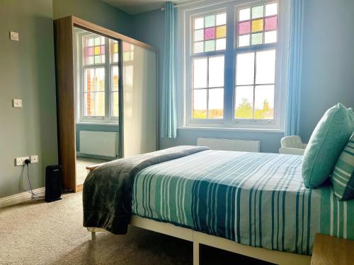 浦耳Lovely 2 Bed 2 Bath Flat with FREE Parking的一间卧室配有一张蓝色墙壁和窗户的床