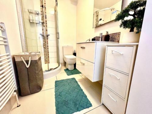 浦耳Lovely 2 Bed 2 Bath Flat with FREE Parking的浴室设有卫生间和带地毯的淋浴。