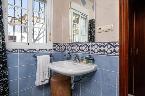 奇克拉纳－德拉弗龙特拉Chalet Estribor的蓝色瓷砖浴室设有水槽和镜子
