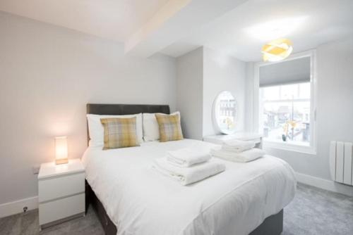 布伦特伍德Modern,central 1 bedroom flat的白色的卧室设有一张大床和一个窗户