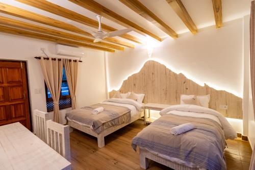 博卡拉Purna的配有木天花板的客房设有两张床。