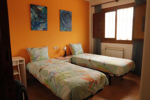 CantoriaVilla Soluna的橙色墙壁客房的两张床