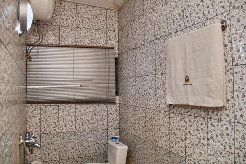 阿布贾GLAMOUR PARK'S HOTEL, ABUJA的浴室配有卫生间和墙上的毛巾