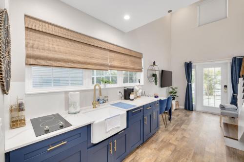 达尼丁SHELLY - Cozy 1 bedroom tiny home with pool的厨房配有蓝色橱柜和窗户。