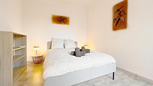 尼斯Le Richemond - 50m de la MER的卧室配有一张白色床,墙上挂有两张照片