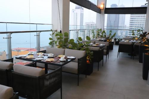 科伦坡Sofia Colombo City Hotel的用餐室配有桌椅和大窗户
