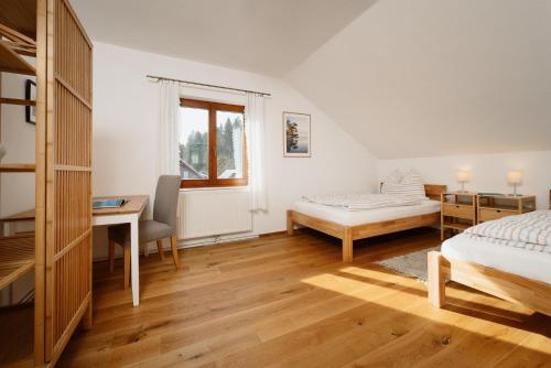 格伦德尔湖Haus Grundlsee的一间卧室配有一张床、一张桌子和一张床