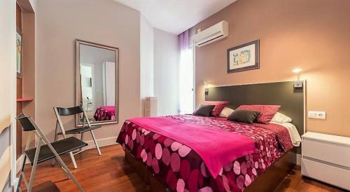 马德里Gran Vía 55 - Excellent Apartments的一间卧室配有一张大床和镜子