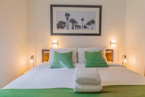 迈阿密海滩1-Bed Apt with rooftop pool Ocean Dr by the Beach的一间卧室配有带绿色和白色枕头的床