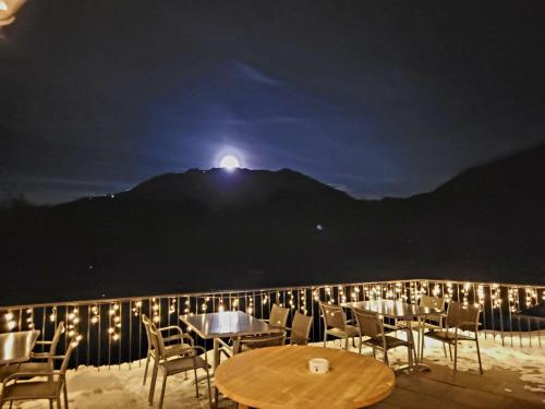 施伦斯Berggasthof Grabs的一个带桌椅的庭院,晚上与月亮相映