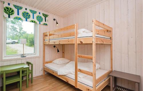Holmsjö斯科格斯托普斯嘉德霍尔姆斯约度假屋的配有书桌和窗户的客房内的双层床