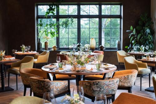 北安普敦The Falcon Hotel的用餐室设有桌椅和窗户。