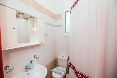 Ayía ParaskevíVilla Giorgos的白色的浴室设有水槽和卫生间。
