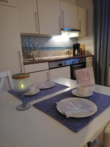 格雷沃斯米伦Heimathafen 1的厨房配有带盘子和台灯的桌子