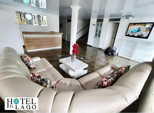 莫科阿Hotel El Lago的客厅配有白色的沙发和桌子