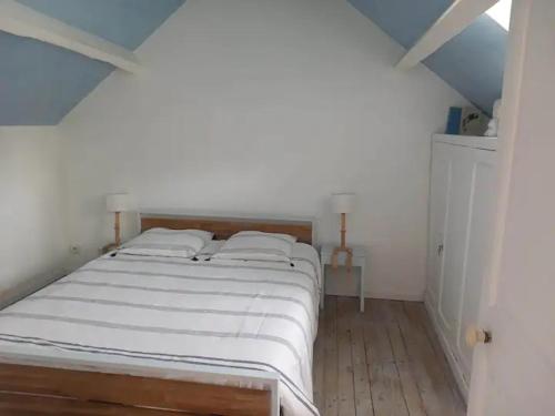 布尔日Chambre bleue avec accès plage的一间卧室配有一张带白色床单的大床