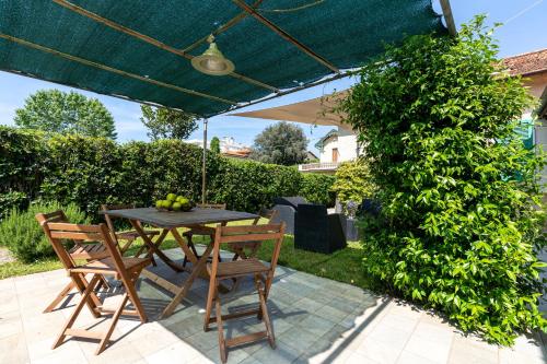 马里纳-迪-皮特拉桑塔Beach House with private garden的露台的遮阳伞下的桌椅