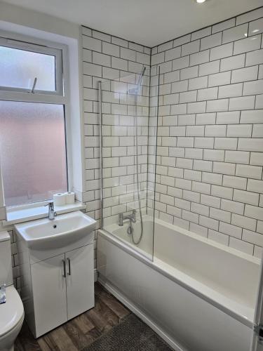 曼彻斯特Stylish & Quiet Space的浴室配有卫生间、浴缸和水槽。