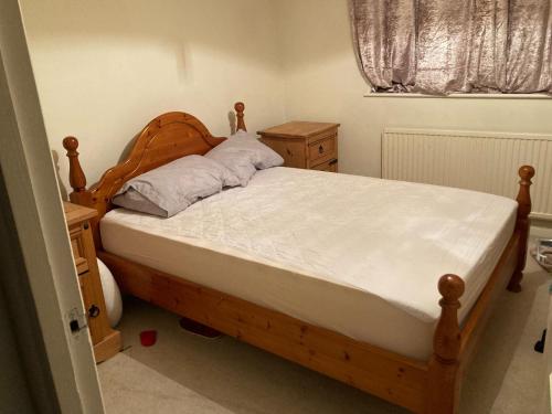查塔姆Ramilies Homes的一间卧室配有一张带木制床头板的床