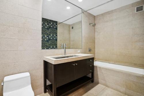 纽约FURNISHED Oversized 1 Bedroom with Home Office (Short-Term Available)的浴室配有盥洗盆、卫生间和浴缸。