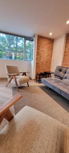 波哥大玛格丽塔公寓的一间卧室配有一张床、一张沙发和一张桌子