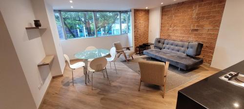 波哥大玛格丽塔公寓的客厅配有沙发和桌椅