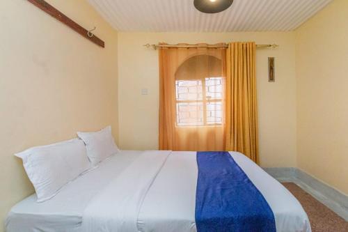 内罗毕City Space Hotel的一间卧室设有一张大床和一个窗户。
