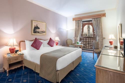 麦地那InterContinental Dar Al Iman Madinah, an IHG Hotel的酒店客房设有一张大床和一张书桌。